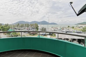A balcony with a view of a marina, boats, and distant mountains. - Peaceful 1-Bedroom Unit at Marina Island by JoMy Homestay (Manjung)