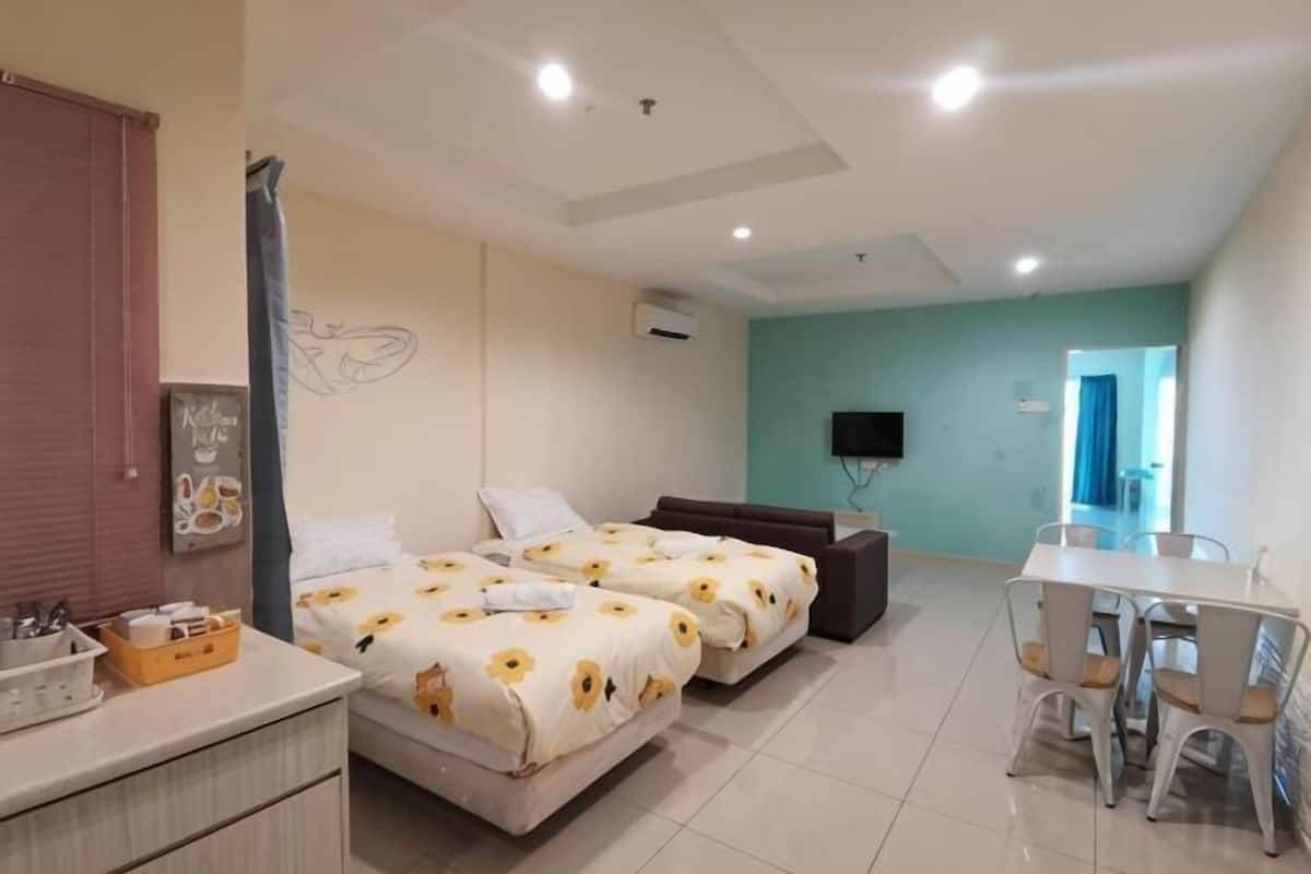 Une chambre d’hôtel avec deux lits, un bureau et une télévision.