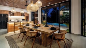 Una cocina moderna con armarios de madera, una isla central e iluminación colgante.
