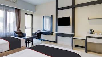 A hotel room with two beds, a desk, a chair, a TV, and a window with curtains.