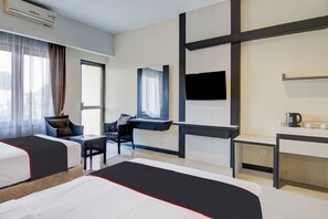 A hotel room with two beds, a desk, a chair, a TV, and a window with curtains. - Townhouse Oak Pekanbaru Near Mall Pekanbaru (Pekanbaru)