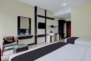 Une chambre d’hôtel avec deux lits, un bureau, une chaise et un grand miroir.