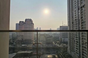 Un immeuble de grande hauteur offrant une vue dégagée sur le paysage urbain, y compris d’autres bâtiments et une tour située au loin.