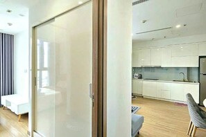 A modern interior with a sliding glass door leading to a kitchen area.