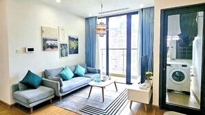 A modern living room with a sofa, coffee table, and artwork on the wall. - Luxury 2Br Vinhomes Skylake - City view/Landmark 72 (Hanoi)