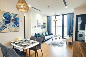 Un salon moderne comprenant un coin repas, un canapé et un espace cuisine.