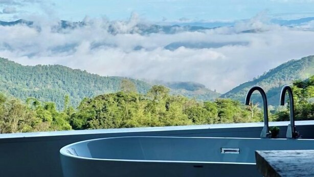 A rooftop pool with a view of forested mountains and clouds. - Merrin Farm (Mae Suai)
