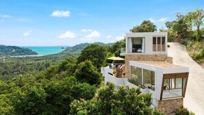 A modern house with a glass facade, a balcony, and a view of the sea. - Villa Bella Vista Samui - 360 Degrees Mountain View (Koh Samui)