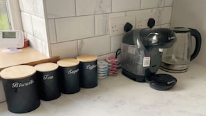 A kitchen with a coffee maker, a kettle, and storage containers labeled 'Biscuits', 'Tea', 'Sugar', and 'Coffee'. - Your Home-from-home - Business & Families - 6 Beds (Ilford)