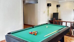 A pool table with balls and cues, a television, and speakers in a room with white walls and a tiled floor. - Tropical Pool Villa Langkawi (Langkawi)