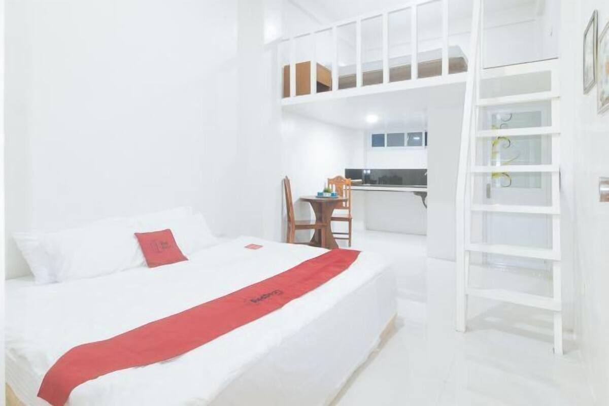 Ein Hotelzimmer mit Bett, Schreibtisch und einer Küchenzeile.