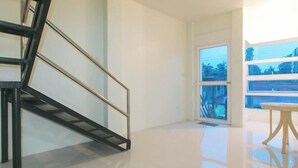 Een modern interieur met een trap, een groot raam en een glanzende vloer.