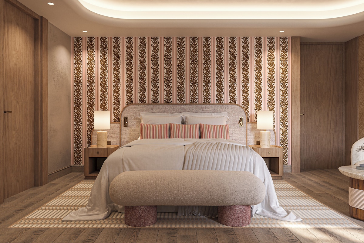 Ein modernes Schlafzimmer mit einem großen Bett, zwei Nachttischen, einer Bank und einer Wand mit Muster.