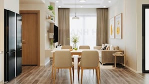 Eine moderne Küche mit Kühlschrank, Holzschränken und einem Essbereich mit Tisch und Stühlen.