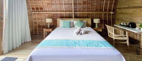 A wooden room with a bed, a desk, and a chair.