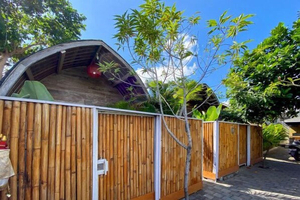 A wooden fenced area with a covered structure, possibly a shed or storage, and a small tree in the foreground.