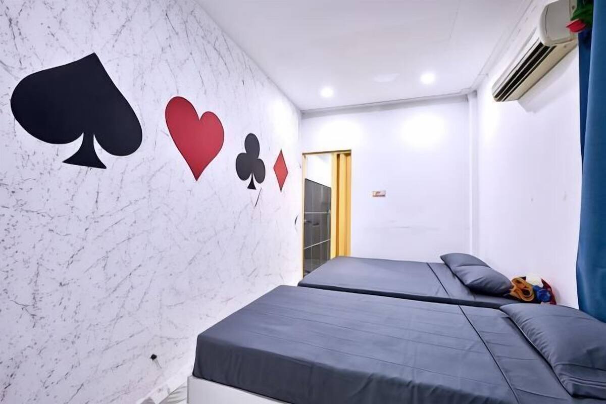A room with two beds, a marble wall, and a door.