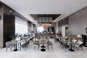 A modern restaurant with a central bar, multiple dining tables, and a contemporary interior design. - Wyndham Garden Legend Halong (Ha Long)