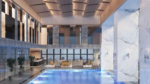 A modern indoor swimming pool with a reception area and seating. - Wyndham Garden Legend Halong (Ha Long)