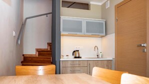 Una cocina compacta con armarios de madera, microondas integrado y cafetera.
