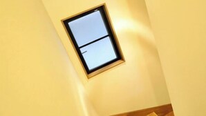 A room with a skylight window and a wooden floor.