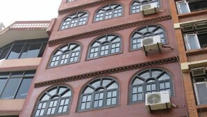 A multi-story building with arched windows and air conditioning units. - Thamel Holiday Apartments (Kathmandu)