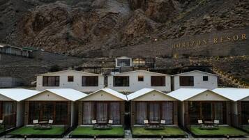 Un hotel con varias habitaciones, cada una con balcón y vistas del paisaje circundante.