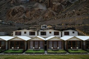 A hotel with multiple guest rooms, each with a balcony and a view of the surrounding landscape.