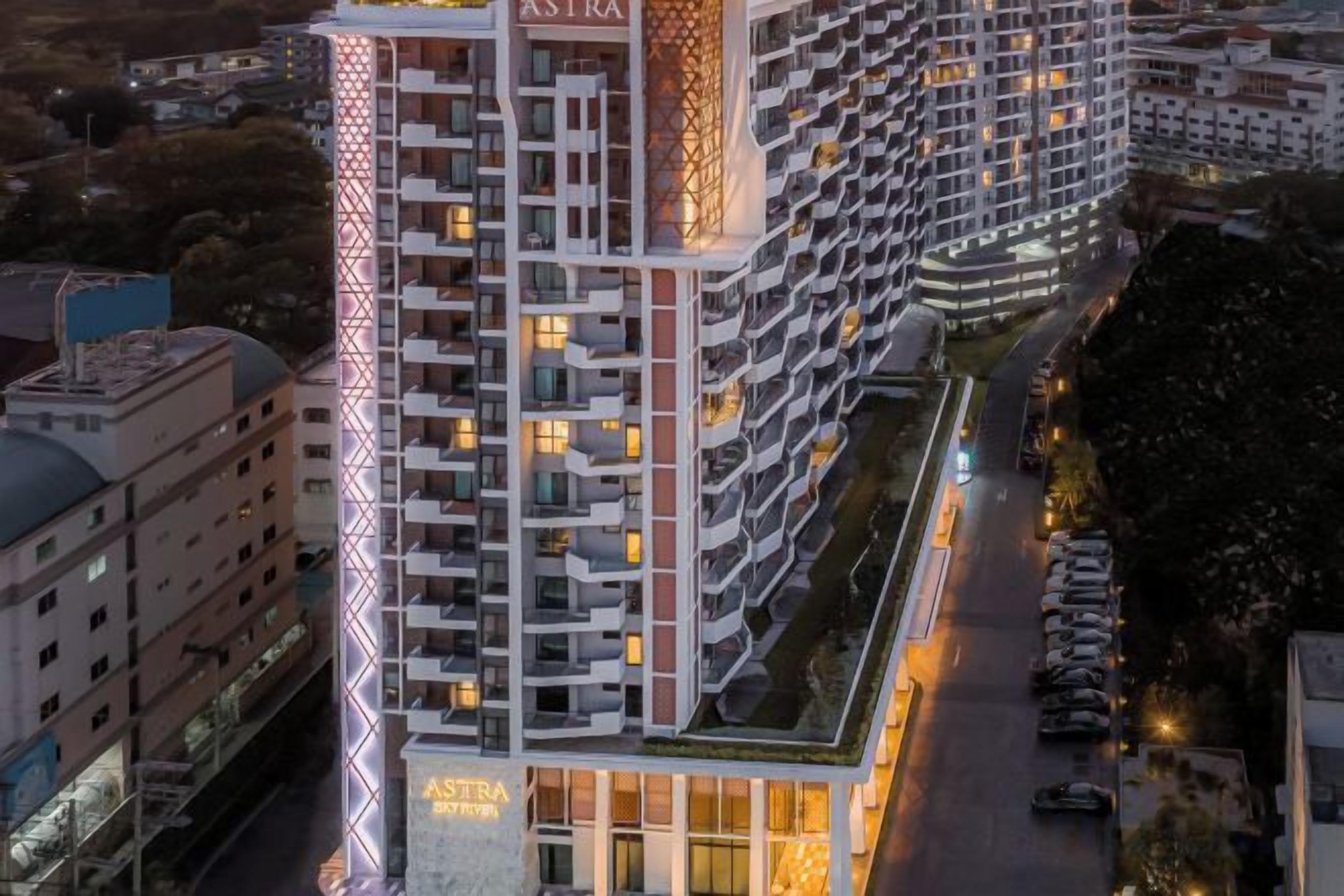 A multi-story hotel with balconies, a prominent 'ASTRA' sign, and a well-lit facade.