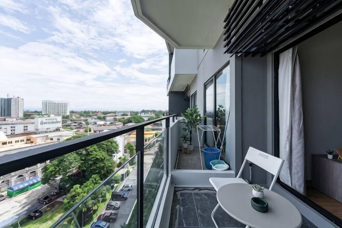 A balcony with a table, chair, and potted plant.