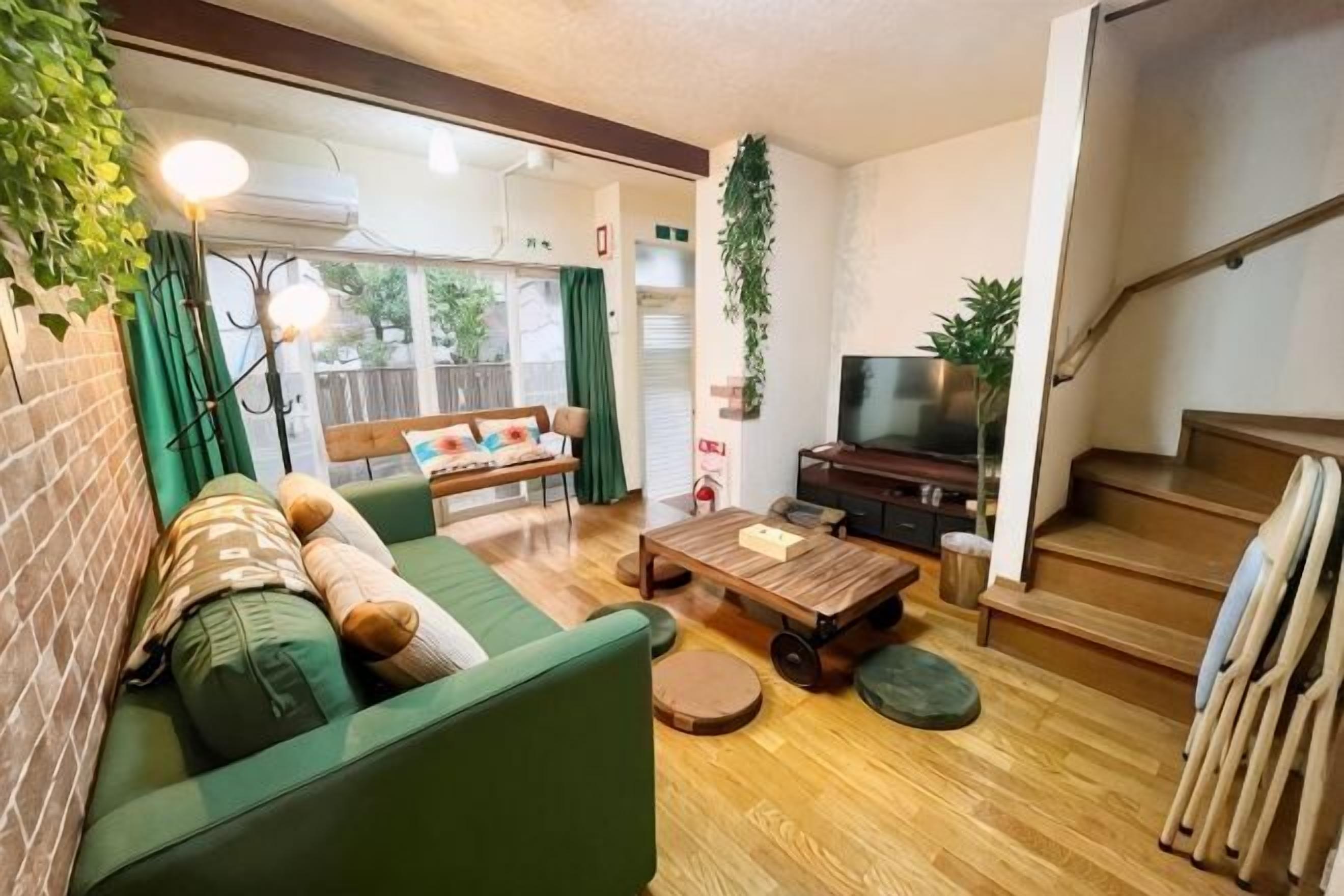 Un salon avec un canapé, une table basse, un téléviseur et un escalier.