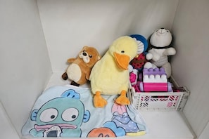 Una col·lecció de joguines de peluix i un tren de jocs en un espai reduït.