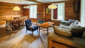 A cozy cabin interior with a dining table, chairs, a sofa, and a window with curtains. - 2 bedroom gorgeous home in Rottneros (Rottneros)