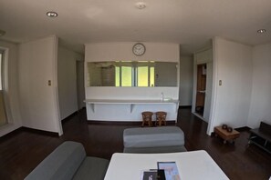 A modern room with a large bed, a sitting area, a small table, and a large mirror. - Ultra Private Off Grid Island Villa Near the Beach Mandarin Farm Setting (Bizen)