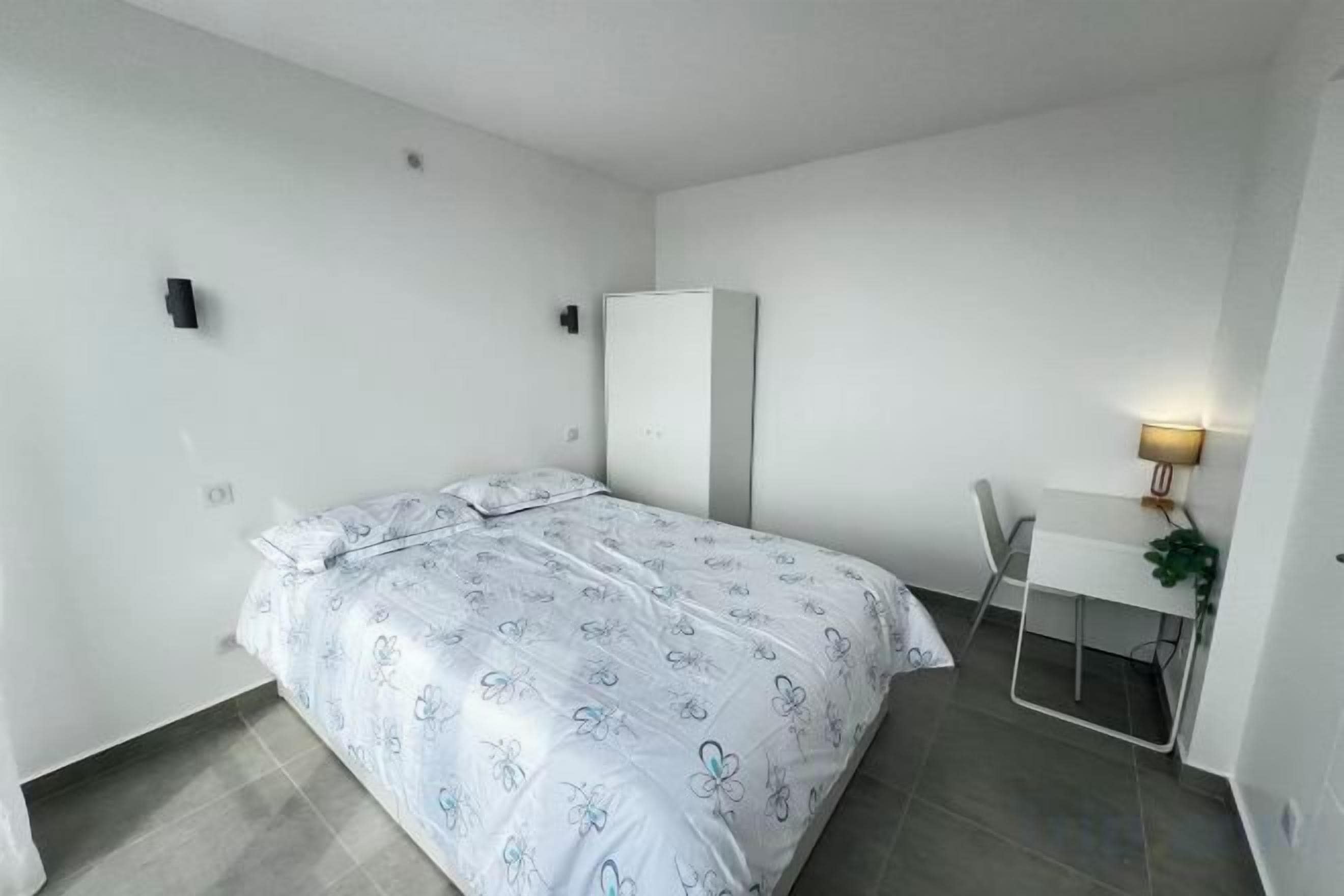 Ein Schlafzimmer mit einem Bett, einem Schreibtisch und einem Stuhl.