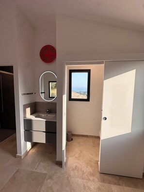 A modern bathroom with a sink, mirror, and a view of the outdoors.