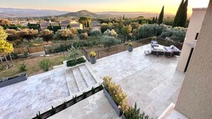 Una terrazza sul tetto con vista su un paesaggio rurale, tra cui alberi e colline lontane.