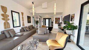 Un soggiorno moderno con un divano componibile, una poltrona relax e un tavolino in marmo.