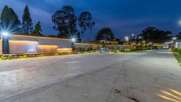 A well-lit parking area with a modern building in the background.