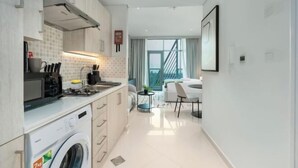Eine moderne Küche mit Waschmaschine, ein Essbereich mit Tisch und Stühlen sowie eine Treppe, die zu einer oberen Etage führt.