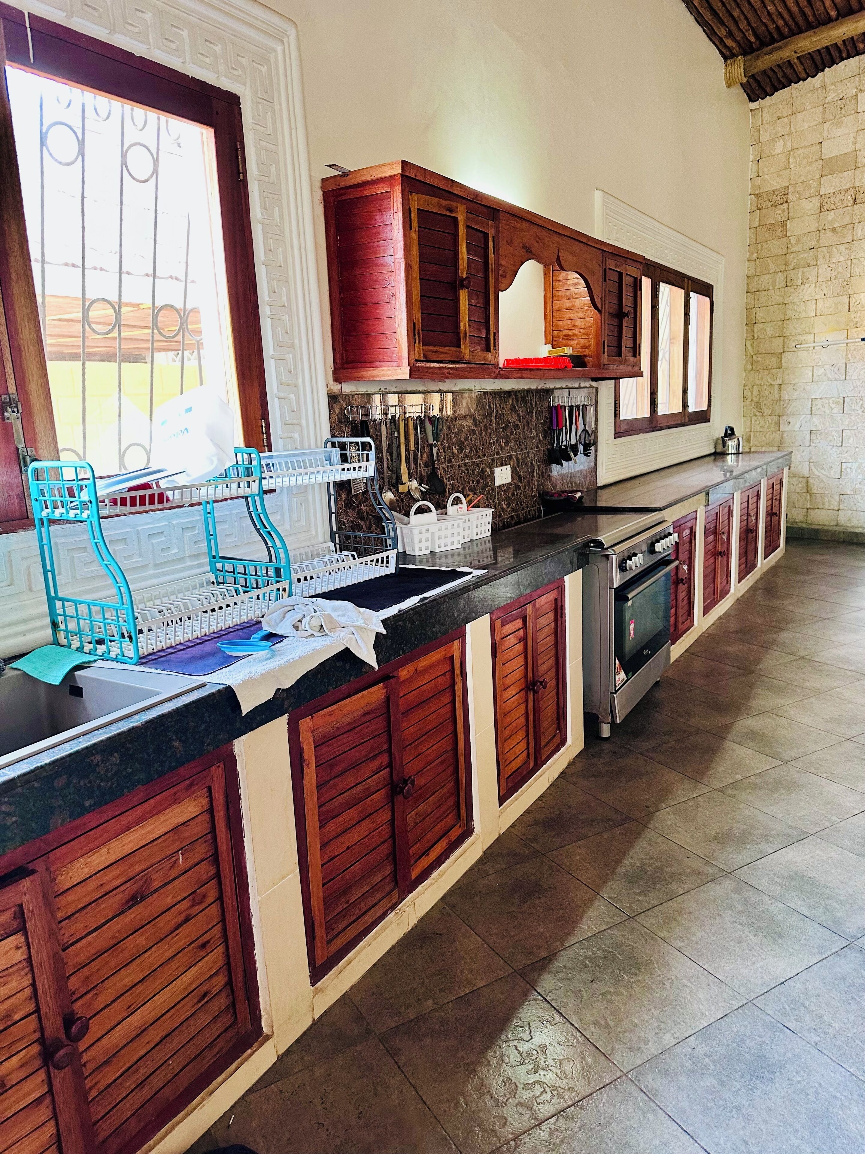 A kitchen with wooden cabinets, a built-in oven, and a dish rack.