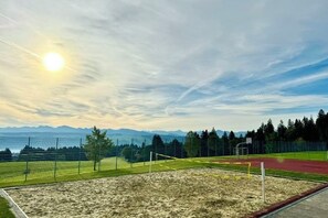 A sports field with a sandpit, goalpost, and running track. - JJ Living - Alpenblick (Scheidegg)