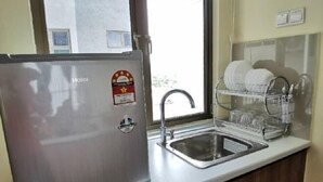 A kitchen with a stainless steel refrigerator, a sink, and a dish drying rack. - Palazio Studio Mount Austin Toppen Ikea by JYNest Johor (Johor Bahru)