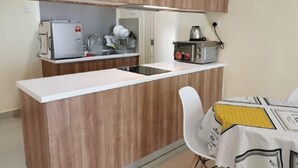 A compact kitchen with a microwave, toaster, and sink. - Palazio Studio Mount Austin Toppen Ikea by JYNest Johor (Johor Bahru)