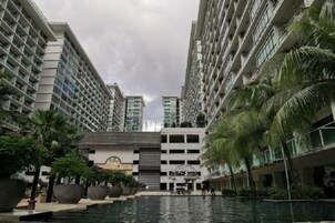 A modern hotel with a central courtyard, multiple floors, and a pool area.