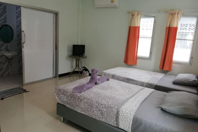 Een hotelkamer met twee bedden, een televisie en een badkamer met een spiegel en wastafel.