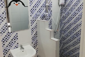 A bathroom with a sink, mirror, and shower. - Ocean Room (Bangkok)