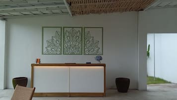 A reception desk with a wooden top, a white panel, and a decorative panel with geometric patterns.