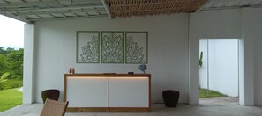 A reception desk with a wooden top, a white panel, and a decorative panel with geometric patterns. - Palm Springs Bali Dive Resorts (Tulamben)