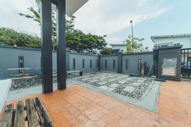 A courtyard with a tiled floor, a wooden bench, and a metal gate.